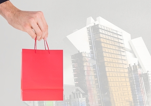 Digital composite of Hand holding Shopping bag against buildings