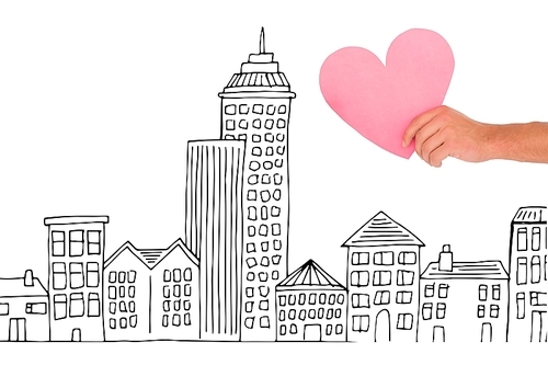 Digital composite of Hand holding Heart against city drawing