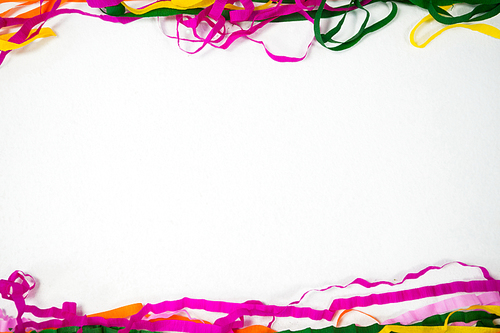 Overhead of colorful streamers arranged on white background