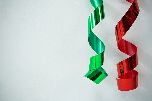 Close-up of red and green streamers on white background