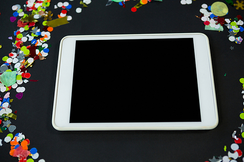 Close-up of digital tablet surrounded by confetti