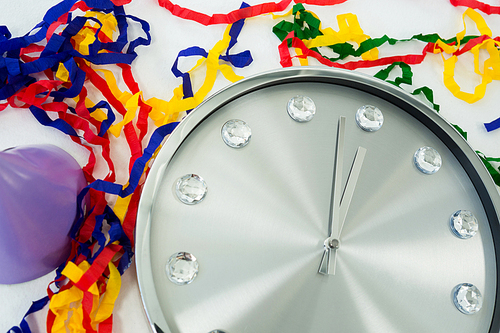 Close-up of clock and streamers against white background