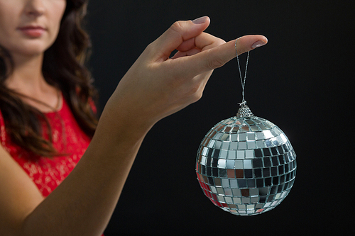 Mid section of woman holding mirror ball