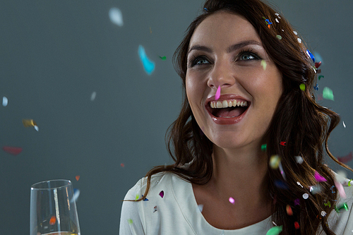 Happy woman celebrating the New year with falling confetti and champagne