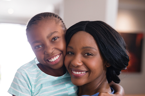 Close up portrait of happy mother and daughter at home