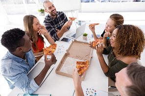 Group of executives interacting while having pizza in conference room