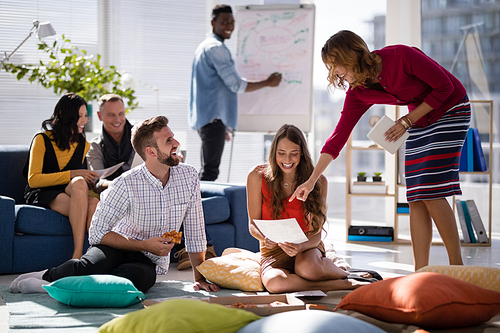 Happy executives discussing over document in office