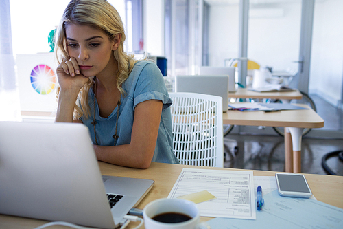 Stressed female executive working at her desk in office