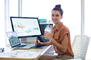 Portrait of female executive working over graphic tablet at her desk in office