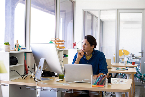 Thoughtful male executive working over laptop at his desk in office