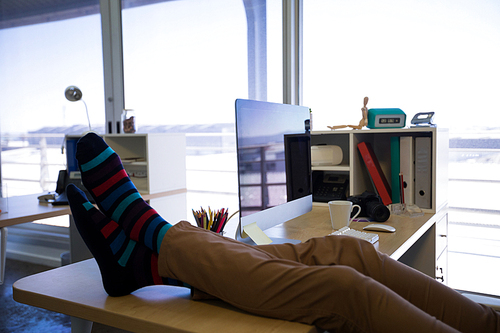 Male executive relaxing at his desk in office