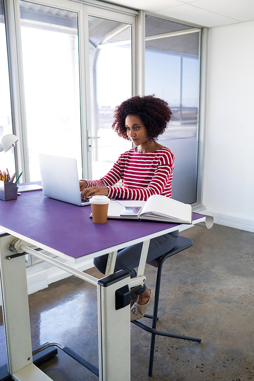 Female executive working over laptop in office