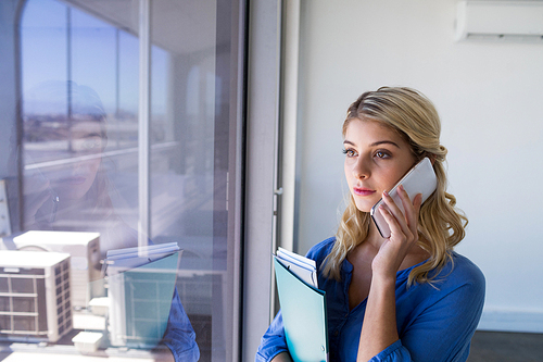 Female executive talking on mobile phone in office