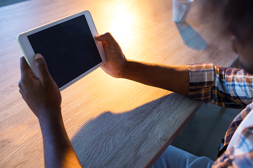 Male executive using digital tablet at his desk in office