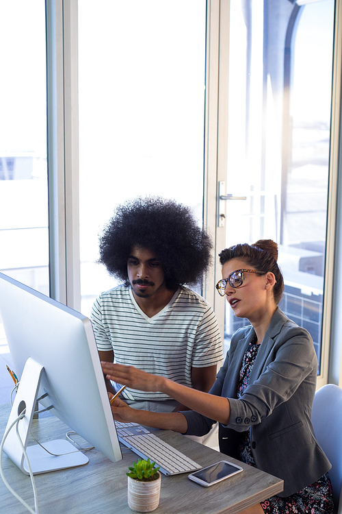 Executives discussing over computer in office