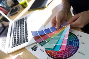 Close-up of female executives holding color shade swatch at her desk in office