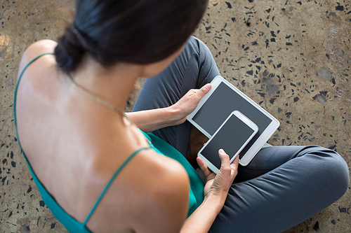 Close-up of female executive using digital tablet and mobile phone in office