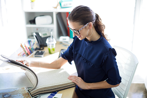 Female executive looking at sample book in office