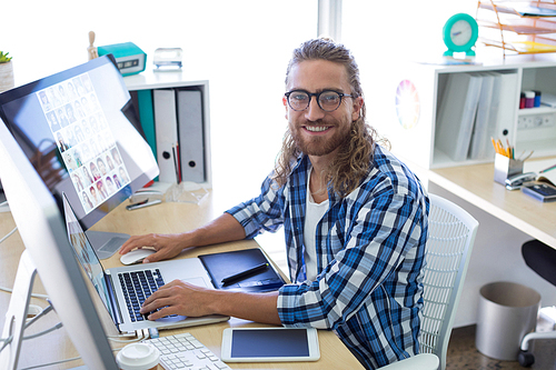 Portrait of male executive sitting at his desk in office