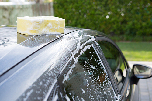 Close-up of soaked wet sponge kept on roof of car