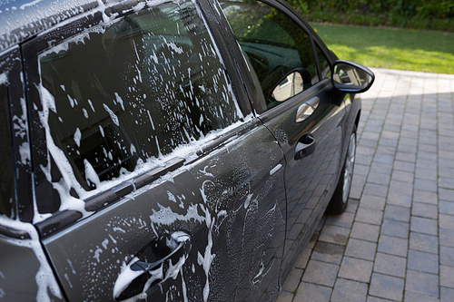 Half washed car with soap foam at outdoors