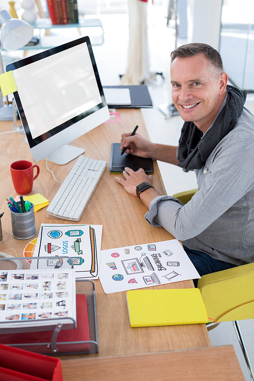 Male graphic designer working at desk in the office
