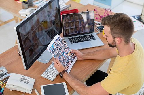 Male executive looking at photos at desk in the office