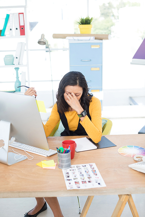 Depressed female executive working on computer in the office