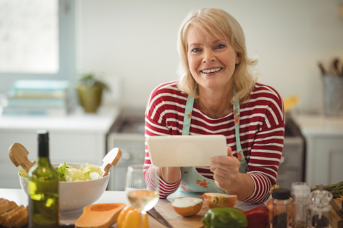 Senior woman using digital tablet in kitchen