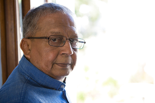 Close up portrait of serious senior man by window in nursing home