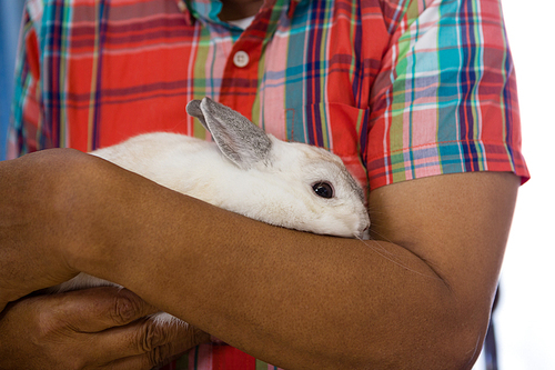 Midsection of senior man holding rabbit at retirement home
