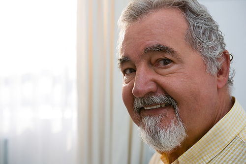 Close up portrait of happy senior man in retirement home