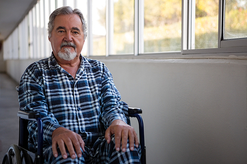 portrait of senior man sitting on . by window in nursing home