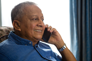 Close up of smiling senior man talking on mobile phone in nursing home