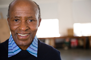 Close up portrait of happy senior man in art class