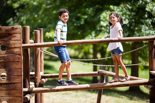 Kids standing on a playground ride in park on a sunny day