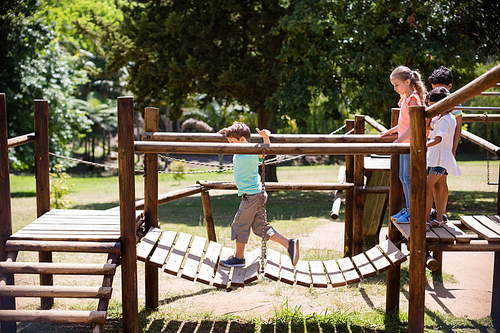 Kids playing on a playground ride in park on a sunny day