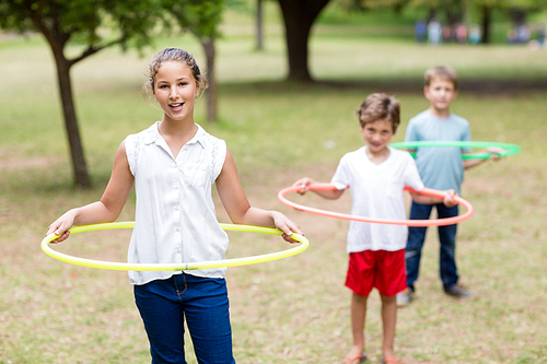 Kids playing with hula hoop in park