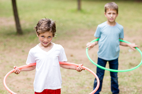 Two boys playing with hula hoop in park