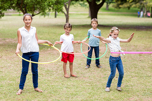 Kids playing with hula hoop in park
