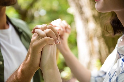 Mid-section of couple holding hands in garden