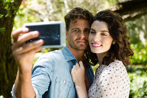 Couple taking selfie from mobile phone in garden