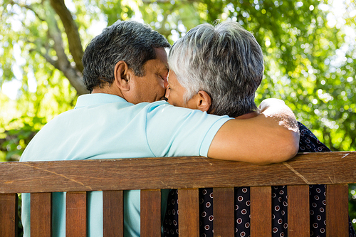 Senior couple kissing at the park on a sunny day