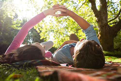 Romantic couple lying on picnic blanket in park on a sunny day