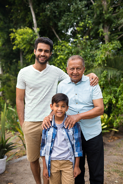 Portrait of smiling family standing against plants at park