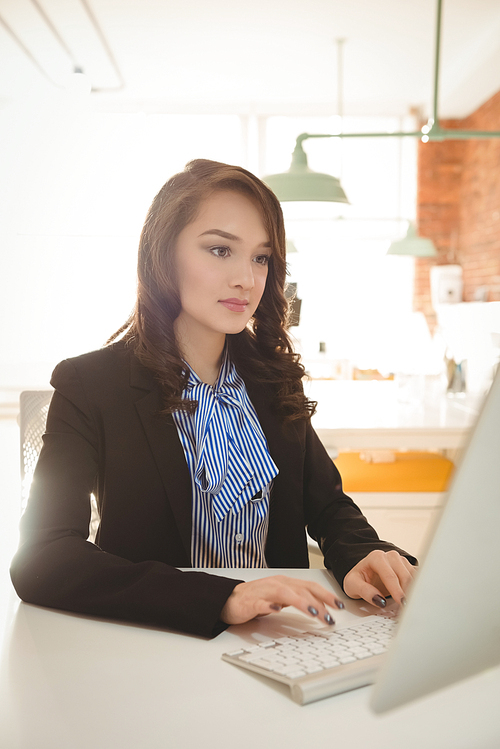 Attentive female business executive working on computer in office