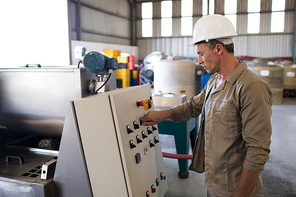 Attentive technician operating a machine in oil factory