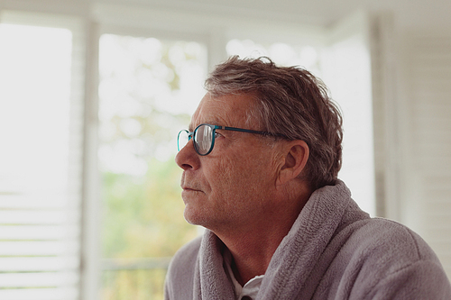 Side view of thoughtful active senior Caucasian man looking away in a comfortable home