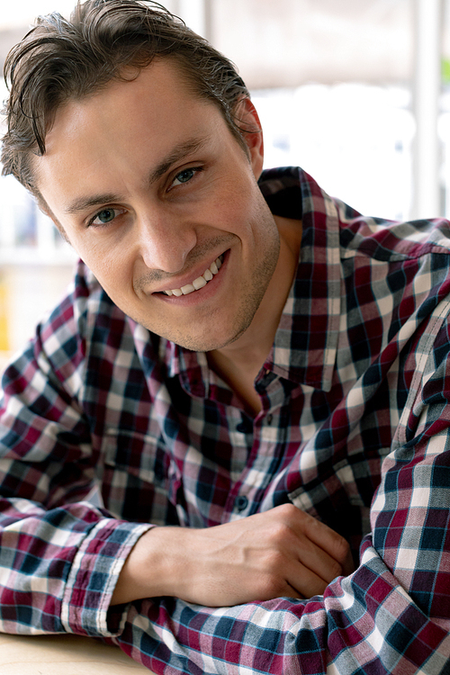 Portrait of happy Caucasian male graphic designer  on desk in a modern office