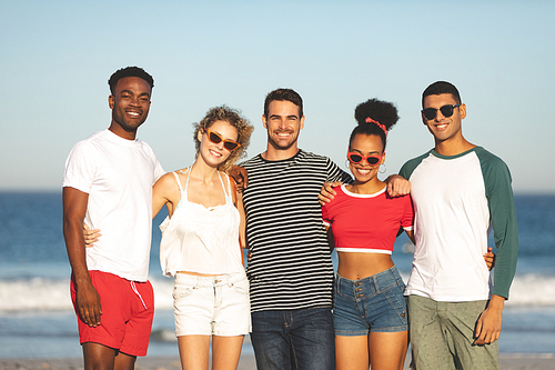 Portrait of diverse friends standing together and looking towards the camera on the beach